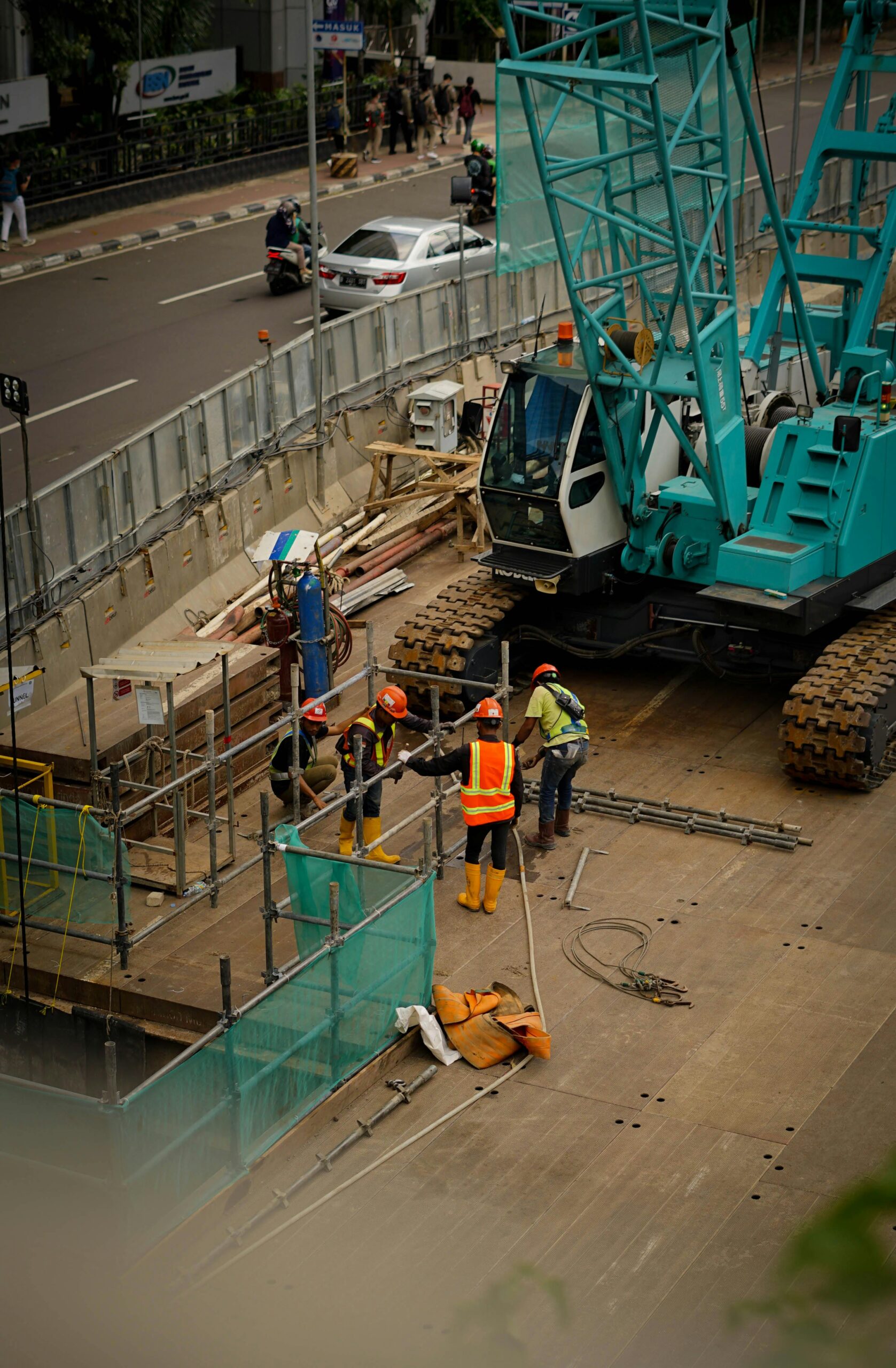 A bustling construction site in Jawa Barat, Indonesia featuring workers and machinery.